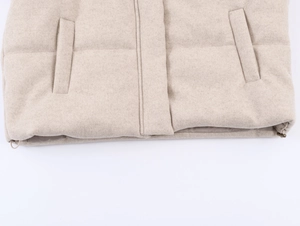 Detail of oatmeal jacket showing adjustable drawstring hem and thick textured fabric