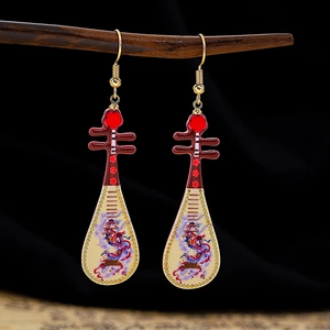 Close-up of Pipa-shaped Chinese earrings with red beads and traditional painted patterns