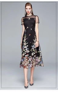 Detailed close-up of heavy floral embroidery on a black mesh high-waist A-line dress