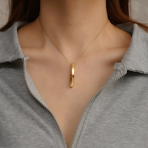 Golden Mobius twist bar pendant necklace on a model showing minimalist style