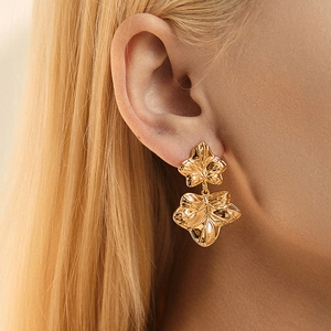 Elegant 18K gold-plated double-layer leaf earrings with realistic textures on model