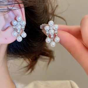 Detail of pearlescent cluster earrings featuring white pearls and sparkling cubic zirconia