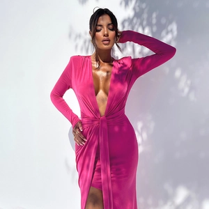 Détail d'une robe longue fuchsia à manches longues, décolleté en V profond et nœud à la taille