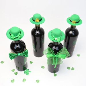 Detailed view of green St. Patrick's Day wine bottle hats and bows with shamrock confetti