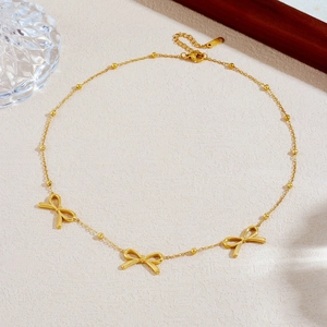 Gold-plated stainless steel bow necklace with bead chain detail and adjustable closure