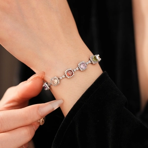 Macro detail of silver vintage bracelet with multicolored gemstones on black velvet