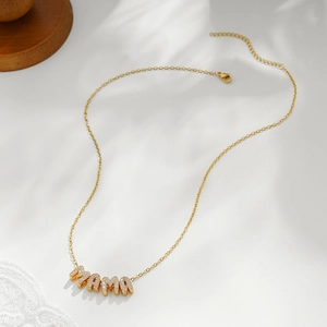 Detail of 18k gold plated MAMA letter pendant necklace with sparkling zircon inlay