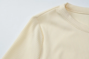 Detail of light yellow ribbed knit cardigan showing the collar and stitching quality