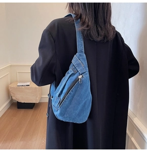 Rear view of a mid-blue denim crossbody bag showing large capacity and waterdrop shape