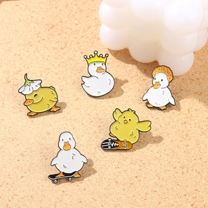 Set of 5 cute yellow duck enamel pins with crown and skateboard designs on cork background