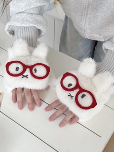Detailaufnahme von flauschigen Hasenhandschuhen mit roten Brillen und Stickerei