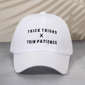 Close-up of black THICK THIGHS X THIN PATIENCE embroidery on a white twill cotton baseball cap