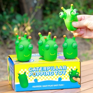 Close-up of hand squeezing green caterpillar popping toy to demonstrate eye-popping fun