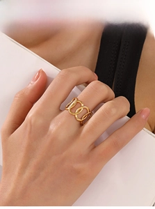 Detail shot of a minimalist gold intertwined geometric oval ring on model's index finger