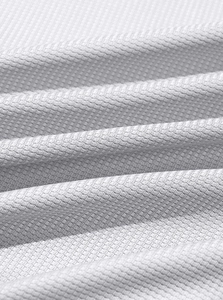 Macro detail of breathable white waffle knit fabric on a men's long sleeve henley shirt