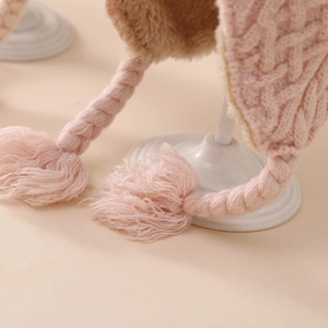 Detailed macro view of pink knit baby hat with warm plush lining and braided ties