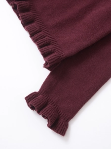 Close-up of burgundy knitted sleeve cuffs with delicate ruffle trim detail
