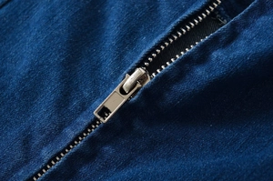 Detailaufnahme eines Metallreißverschlusses an einem dunkelblauen Jeans-Bodycon-Kleid