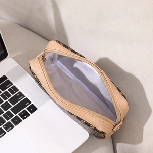 Brown and beige patterned crossbody bag with zipper closure and white inner lining