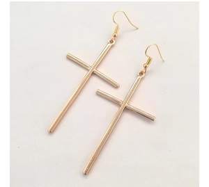 Detailed view of long gold cross drop earrings with hooks on a clean white surface