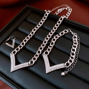 Detail view of silver V-shape jewelry set with rhinestones on black leather tray