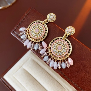 Detailed close-up of Bohemian geometric pearl tassel earrings in a jewelry box