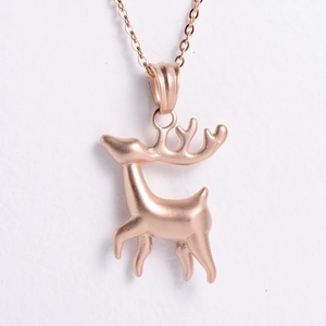 Close-up of rose gold reindeer pendant with detailed metal luster on a cross chain