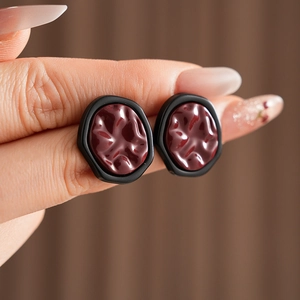 Detail of irregular round studs with wine red resin texture and black outer frame