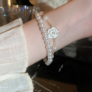 Detail of double-layer bracelet with white camellia pendant and imitation pearls