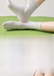 Detail view of white silk crew socks showing seamless toe and ribbed texture design