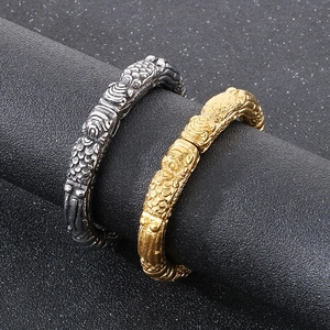 Detailed relief of vintage dragon scale patterns on antique silver and gold wide bangles