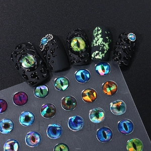 Macro shot of 3D dragon eye nail stickers with colorful cat eye stones and lace details