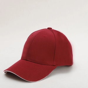 Detail of dark red cotton baseball cap with white contrast piping on the curved brim