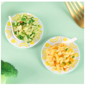 Close-up of miniature fried rice toy models in small white plates for dollhouse decoration
