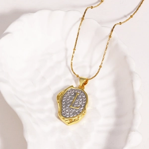 Close-up of gold 18k plated necklace with a zircon-encrusted letter L lava pendant