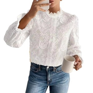 Détail de chemisier blanc à manches longues avec broderies florales élégantes et col à volants