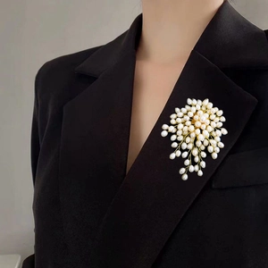 Handmade natural freshwater pearl brooch cluster worn on a black blazer lapel