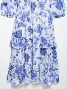 Gros plan détaillé du motif floral bleu et de la texture de la jupe en mousseline à volants