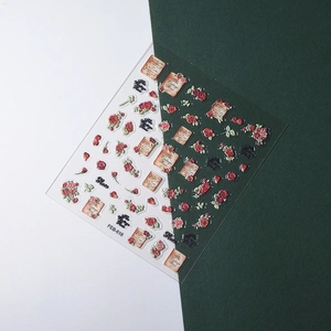 Détail de stickers à ongles 5D vintage avec roses rouges en relief et parchemins