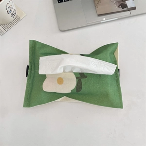 Detail of green floral canvas tissue pouch with black hanging loops on office desk
