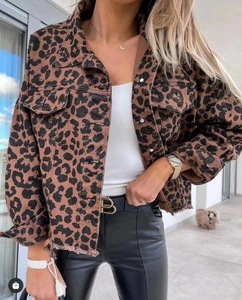 Detailed close-up of leopard print denim jacket with metal buttons and frayed edges