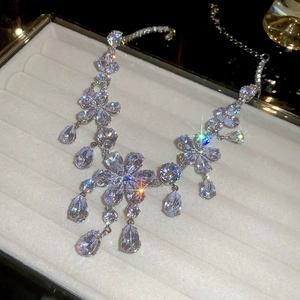 Macro shot of silver-tone flower necklace with teardrop zircon pendants and star-shaped sparkles