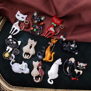 Collection of various cute cat brooches with enamel and crystals on green velvet