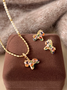 Detail of zebra pendant jewelry set with colorful crystals and pearl necklace chain