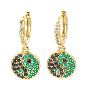 Macro shot of gold-plated Tai Chi earrings with black and green zircon pavé settings