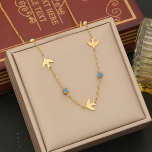 Detail of gold double-layer chain with blue evil eye beads and small bird pendants