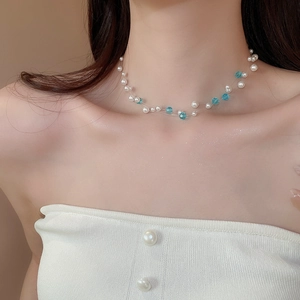 Detail view of multi-layer necklace with white pearls and sky blue crystal glass beads