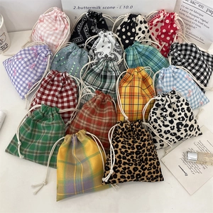 Flat lay of colorful drawstring cotton pouches with plaid, polka dot and animal patterns