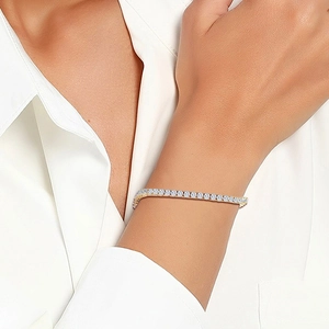 Close-up of a gold-plated tennis bracelet with sparkling round zircons on a wrist