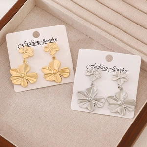 Detail of vintage floral drop earrings in gold and silver finishes on display